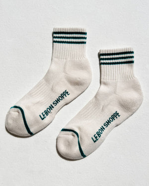 White socks with black text and green accents on a light gray background