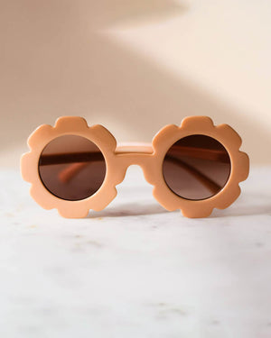 Peach toddler-sized sunglasses with floral-shaped frames on a light background