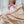 Newborn baby sleeping under a patterned blanket and quilt