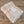 Folded peach and beige plaid blanket with a white label on a wooden surface