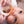 Baby laying down and chewing the wooden ring of a rattle