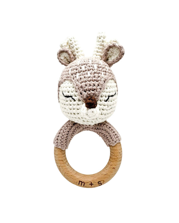 Crocheted animal rattle with wooden ring on a white background