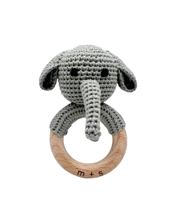 Crocheted elephant rattle with wooden ring on a white background