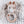 Crocheted giraffe rattle toy on a textured fabric background