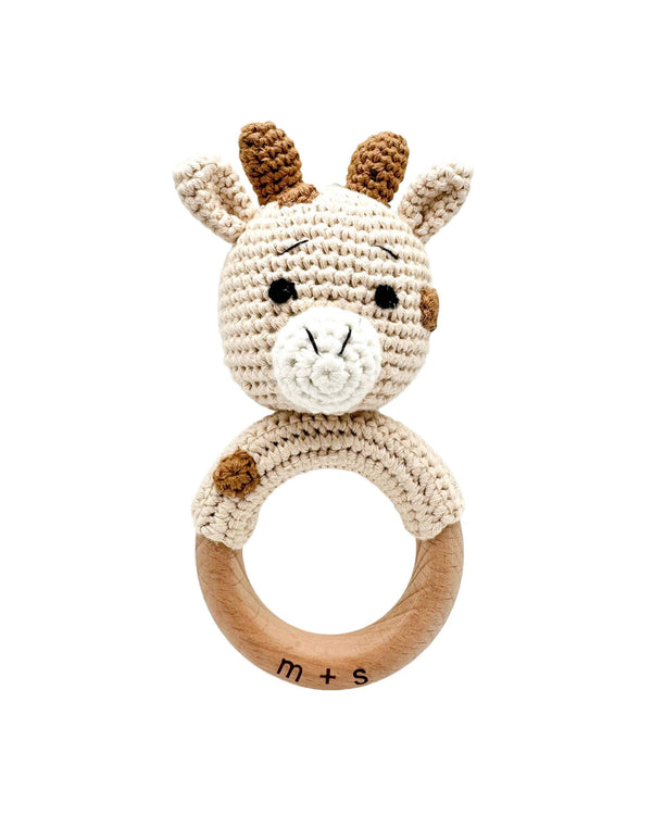 Crocheted giraffe rattle with wooden ring on a white background