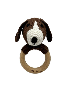 Crocheted dog rattle with wooden ring on a white background