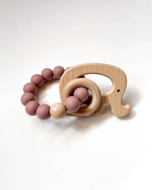 Wooden teething ring with an elephant cut-out and pink silicone beads on a white background