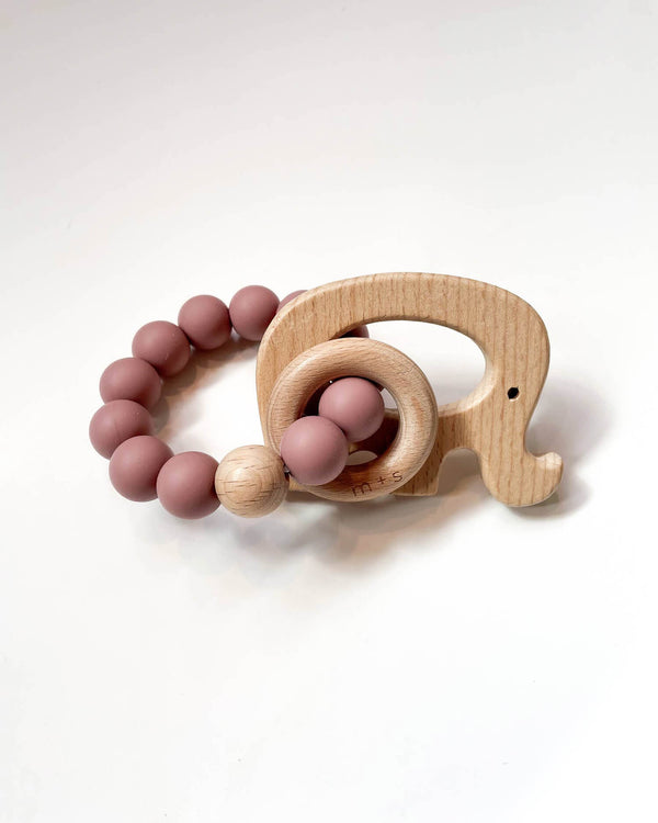 Wooden teething ring with an elephant cut-out and pink silicone beads on a white background