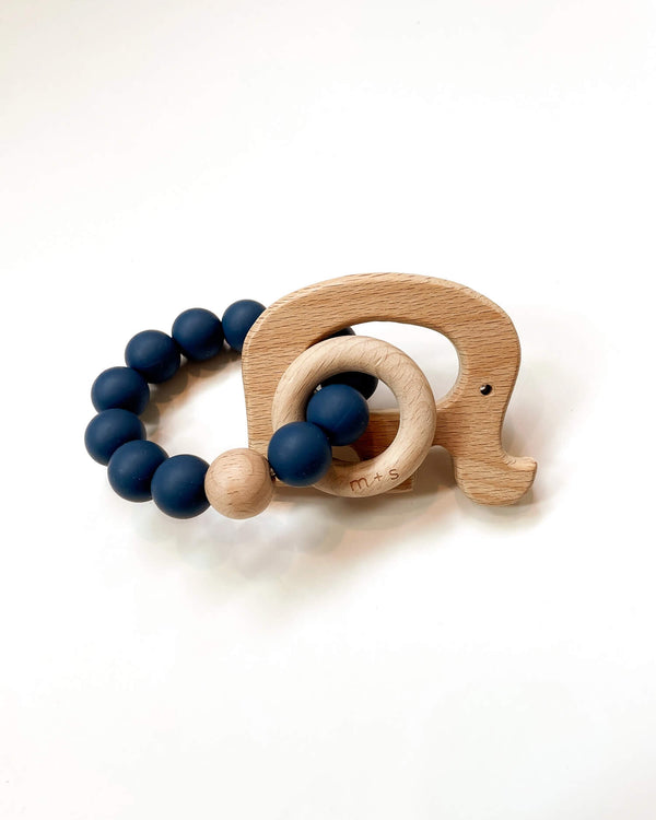Wooden teething ring with an elephant cut-out and navy silicone beads on a white background