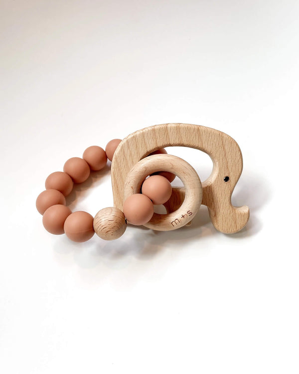 Wooden teething ring with an elephant cut-out and peach silicone beads on a white background