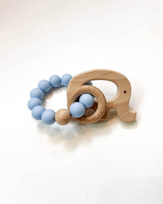 Wooden teething ring with an elephant cut-out and powder blue silicone beads on a white background