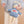 Child holding a teddy bear with 'SKI' on its shirt against a beige background
