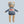 Teddy bear toy dressed in a blue ski outfit with 'SKI' on the back against a light blue background