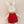 Stuffed bunny toy wearing a red dress with white polka dots on a beige background
