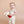 Baby in a white onesie holding a plush strawberry bunny toy against a beige background