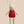 Stuffed bunny toy wearing a red dress with white polka dots and a green leafy neck on a beige background