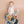 Baby holding a teddy bear with a colorful blanket on a beige background