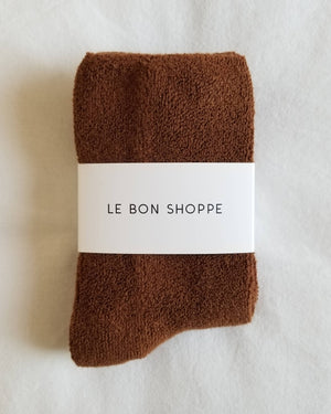 Brown socks with a white label reading 'Le Bon Shoppe' on a light background