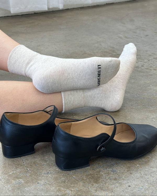 Black shoes and white socks on a concrete floor