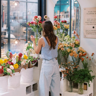Emily Guin selecting fresh seasonal flowers at the Landfall Floral Co. stem bar inside Edgewater Public Market.