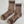 Pair of brown socks with black stripes and 'LE BON SHOPPE' branding on a white background