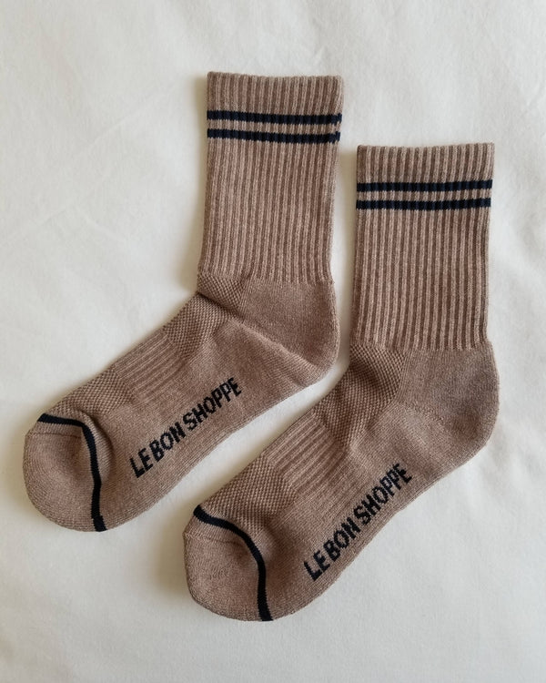 Pair of brown socks with black stripes and 'LE BON SHOPPE' branding on a white background