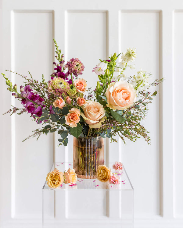Classic Arrangement with garden roses, ranunculus, stock, and snapdragons in a ribbed blush vase, designed in Landfall’s airy, modern style.