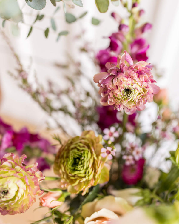 Close-up of ranunculus, snapdragons, and textural accents from the Classic Arrangement in a soft, seasonal palette.