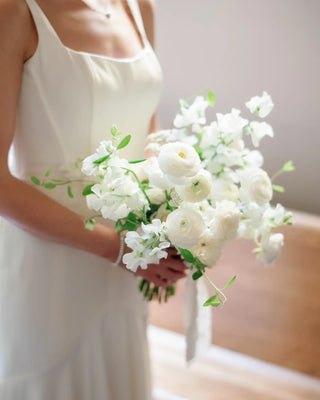 Bride holding an airy white wedding bouquet designed by Landfall Floral Co.