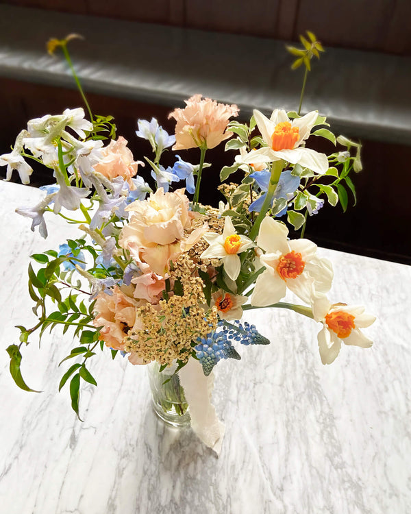 Soft pastel elopement bridal bouquet with delicate seasonal flowers in a loose, romantic arrangement.