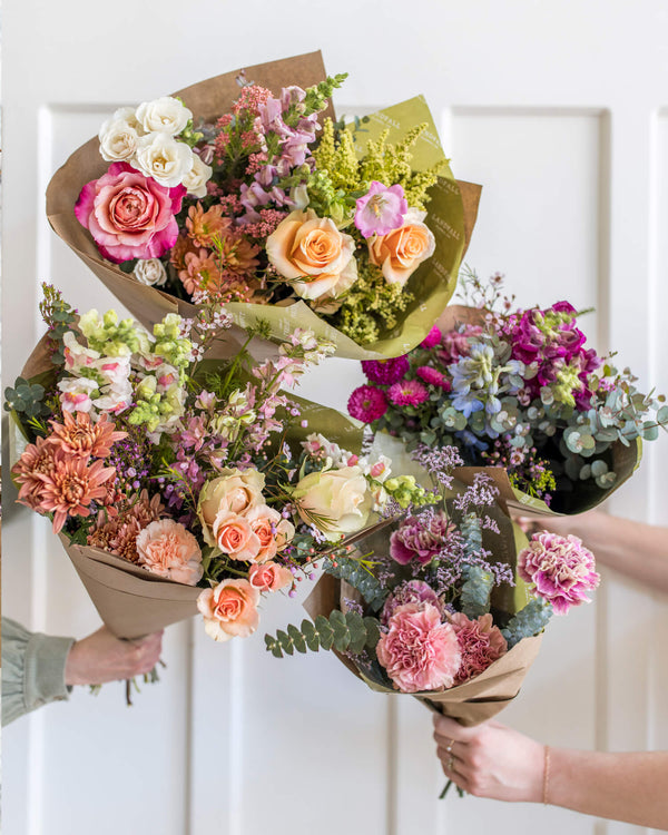 Luxe bouquet shown with other bouquet sizes, featuring seasonal flowers in mixed palettes, designed by Landfall Floral Co.
