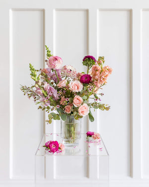ignature Arrangement in a ribbed-glass vase with soft pastel flowers by Landfall Floral Co.