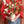 Love Story Valentine’s Day arrangement held by a person in jeans and a red sweater, featuring tulips, ranunculus, snapdragons, and sweet peas in a cream ridged vase.