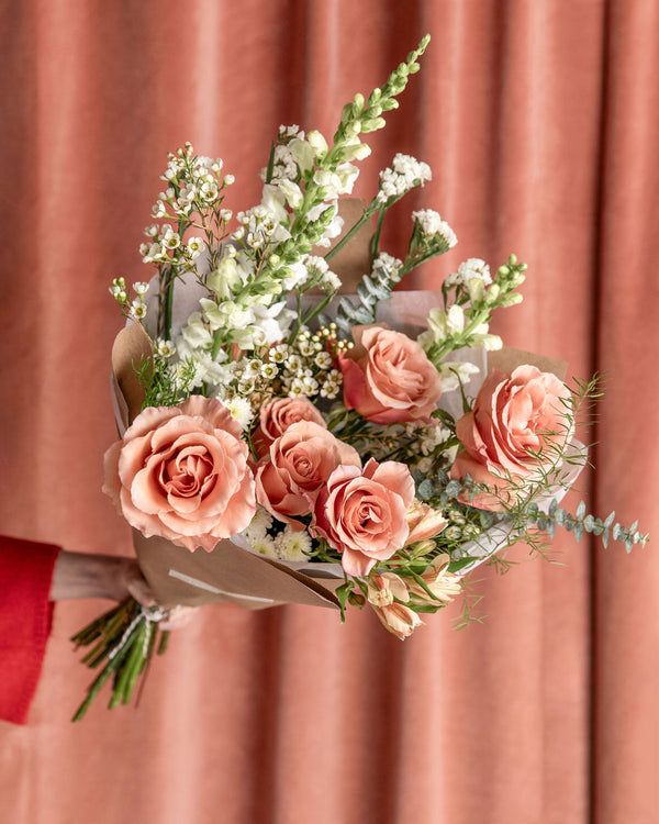 Lovestruck Valentine’s Day Bouquet in the rose-forward version, designed with blush, ivory, caramel, and soft red roses, wild vines, and airy greenery.