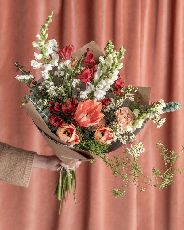 Lovestruck Valentine’s Day Bouquet in the tulip-forward version, featuring locally grown tulips in blush, ivory, caramel, and soft red tones with wild vines and airy greenery.