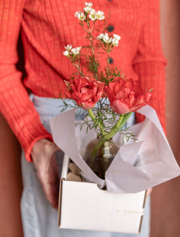 Lovebug Valentine’s Day bud vase displayed in a Landfall gift box, held by a person in a red sweater.
